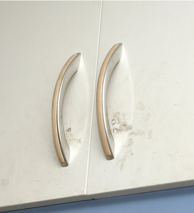 A cabinet with stains around the handles.